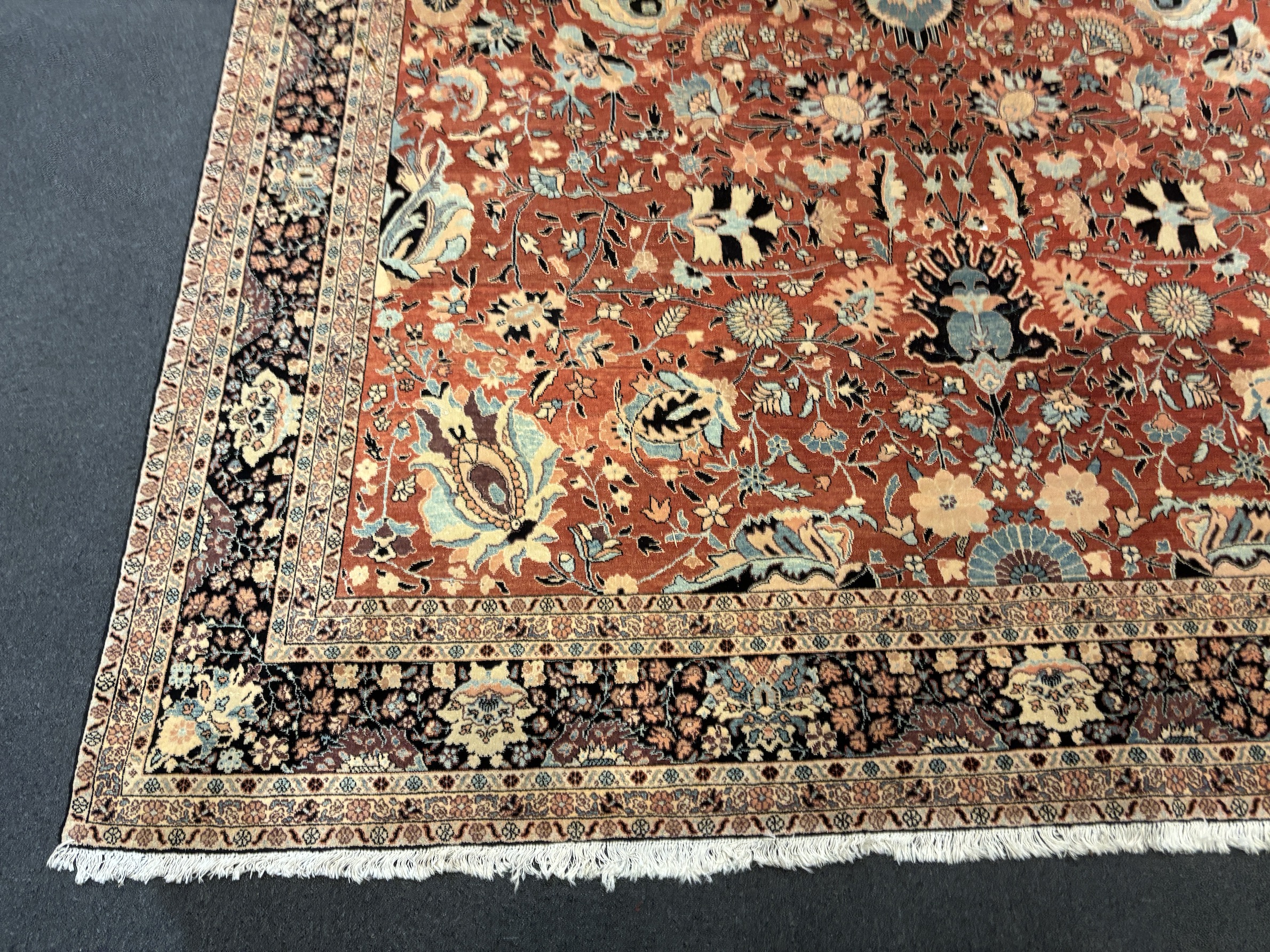 A Tabriz brick red ground gallery carpet 575 x 300cm